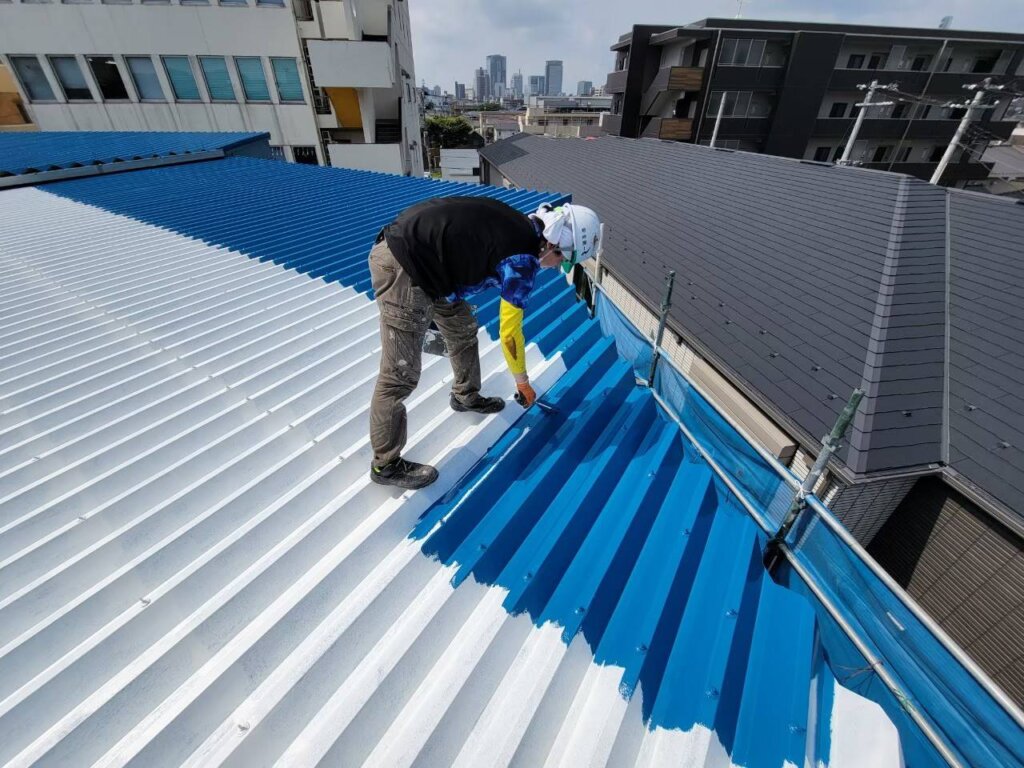 屋根を塗装する作業員